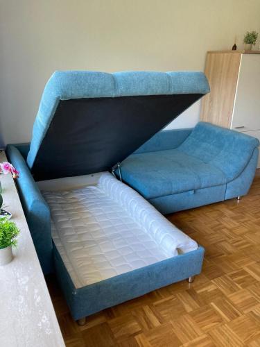 a blue couch and a bed in a room at Waldglück in Wolfshagen
