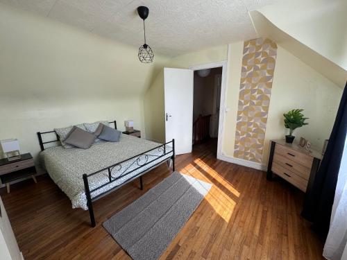 une chambre avec un lit et un parquet dans l'établissement Gîte de Kerg’O, à Cléden-Poher