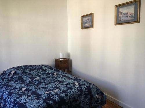 une chambre avec un lit et deux tableaux au mur dans l'établissement Maison entre plage et port, au Pouliguen