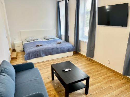 a room with a bed and a couch and a table at Gedimino 19 apartments in the old town of Ukmergė in Ukmergė