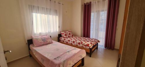 a small room with two beds and a chair at View Saranda Center in Sarandë
