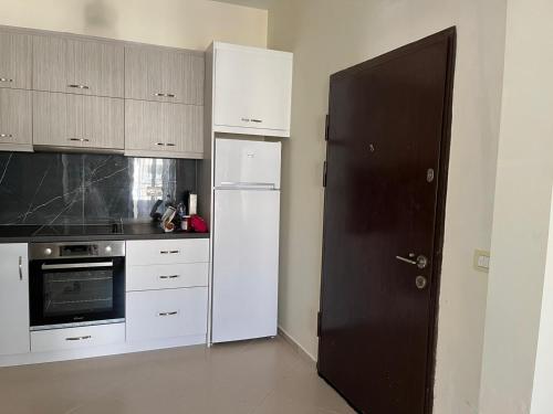 a kitchen with white cabinets and a black door at View Saranda Center in Sarandë