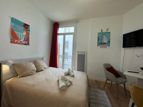a bedroom with a bed and a desk and a window at Petit Splendid - Ancien Palace, Balcon, Centre in Vichy