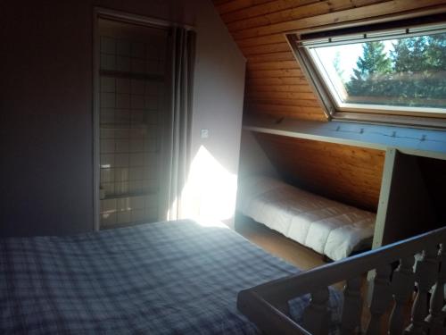 une petite chambre avec un lit et une fenêtre dans l'établissement Les Caribous, à Chastreix