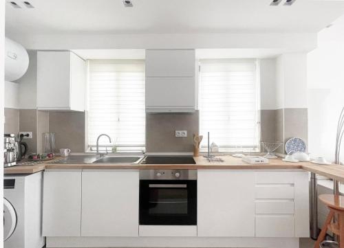 a kitchen with white cabinets and a sink at Place Sainte Marguerite in Provins