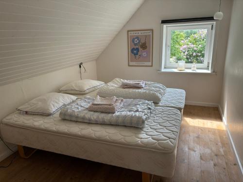 a bedroom with two beds and a window at Feriehus Vrensted-Løkken in Løkken