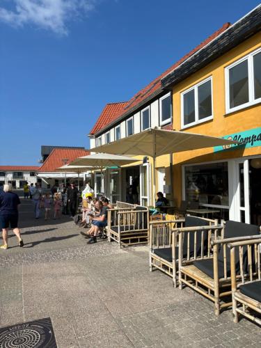 a group of people sitting outside of a building at Feriehus Vrensted-Løkken in Løkken
