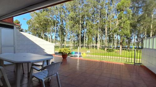 a patio with a table and chairs and trees at Nido Ría in Villaviciosa