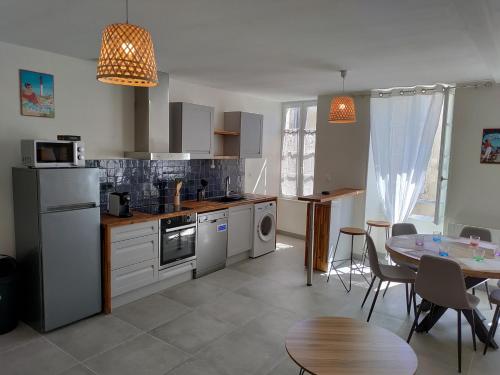 une cuisine avec une table et une salle à manger dans l'établissement Marennes - Duplex cœur de village, à Marennes