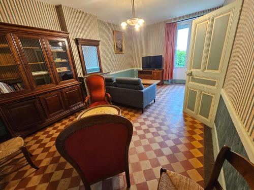 a living room with a couch and a chair at La Maison du Bourg Joly in Bourgueil