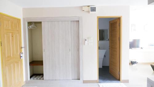 a room with white walls and a door at Shi-ro-i Poshtel in Hat Yai