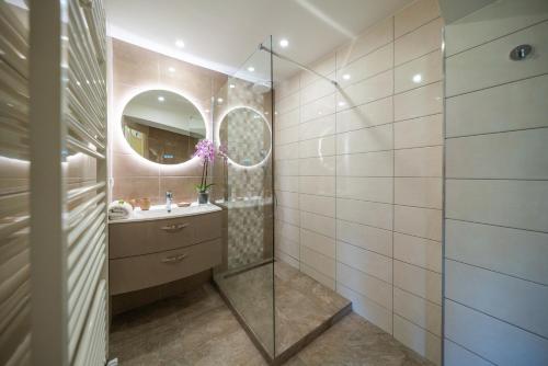 a bathroom with a shower and a sink and a mirror at La Colline de Vence in Vence