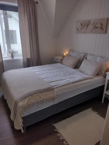 a large bed in a bedroom with a window at Light terrace city apartment Alesund in Ålesund