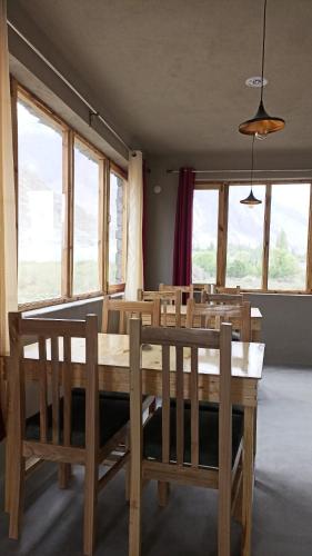 a dining room with a table and chairs and windows at Tsogstot residency in Deskit
