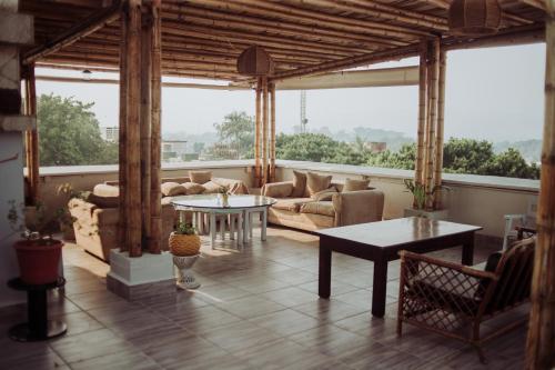 ein großes Wohnzimmer mit einem Sofa und Tischen in der Unterkunft HOTEL WAYAK in Palenque