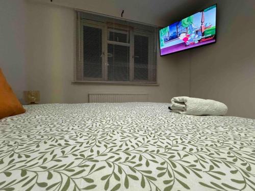 a bedroom with a bed with a tv on the wall at PRP Pennack Road Peckham London in London