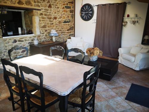 un salon avec une table, des chaises et un canapé dans l'établissement GITE BRETON sur la côte de granit rose, à Pleudaniel