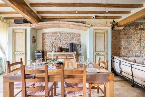 a dining room with a table and chairs and a couch at Villa Dacia in Guiglia