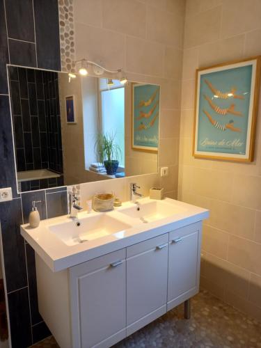 a bathroom with two sinks and a large mirror at Chambre d'hôte Le fer à cheval en bord de Loire in Bully