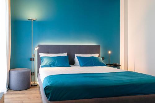 a blue bedroom with a large bed with blue walls at Camoma Aparthotel - Suites Apartments in Jesolo