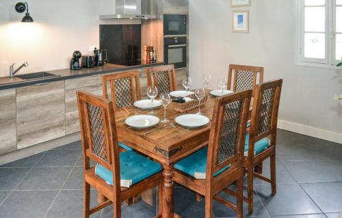 a wooden table with chairs and wine glasses on it at Château De Grenier Gite in Saint-Léger