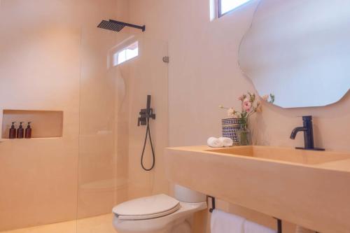 a bathroom with a shower and a toilet and a sink at La Alberca Hotel Boutique in Mazunte