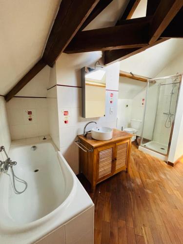 une grande salle de bain avec une baignoire et un lavabo dans l'établissement Logement 4 pers - Cœur de ville - calme - boîte à clé arrivée autonome à partir de 16h00 départ 11h00, à Cholet