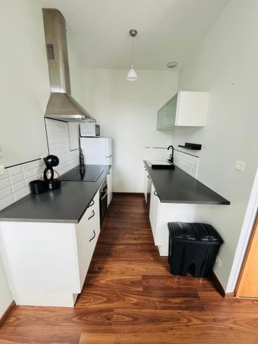 une cuisine avec des armoires blanches et des comptoirs noirs dans l'établissement Logement 4 pers - Cœur de ville - calme - boîte à clé arrivée autonome à partir de 16h00 départ 11h00, à Cholet