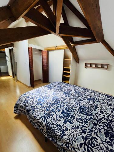 une chambre avec un lit bleu et blanc avec des poutres en bois dans l'établissement Logement 4 pers - Cœur de ville - calme - boîte à clé arrivée autonome à partir de 16h00 départ 11h00, à Cholet