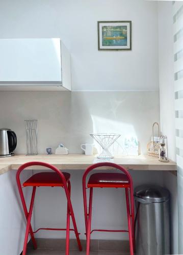 two red stools sitting at a counter in a kitchen at Place Sainte Marguerite in Provins