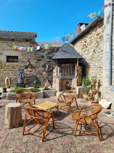 a group of chairs and a table in front of a building at les forges du lou in Jugon Les Lacs