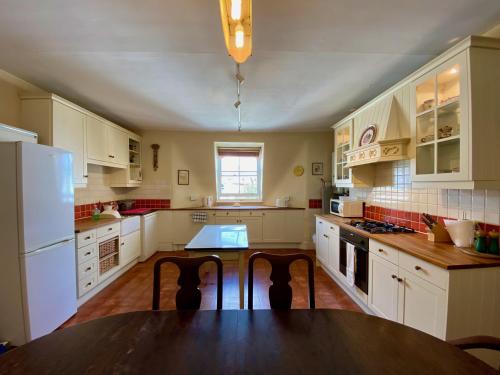 a kitchen with a wooden table and white appliances at Clifton Views in Folkestone