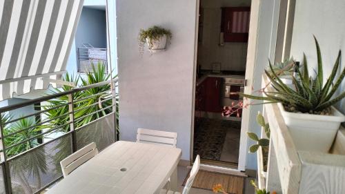 una mesa blanca y sillas en un balcón con plantas en I meridiani, en Montesilvano