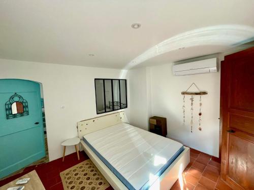 - une chambre avec un lit et une porte bleue dans l'établissement Gite de la Palme, à Lapalme