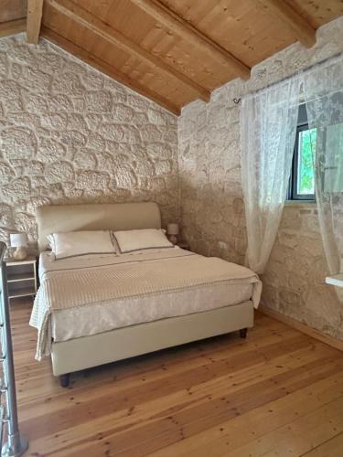 a bedroom with a bed and a stone wall at Sun Castle Houses in Drymon