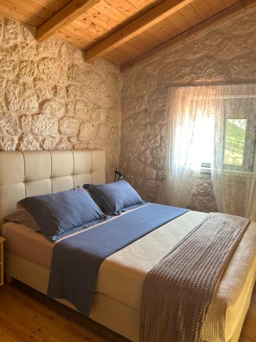 a bed in a room with a stone wall at Sun Castle Houses in Drymon