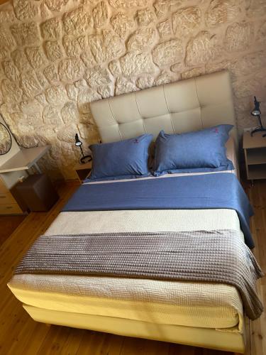 a bedroom with a large bed with blue pillows at Sun Castle Houses in Drymon