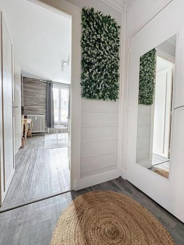 un couloir avec une porte et une plante sur le mur dans l'établissement Studio Chantilly Gare, à Chantilly