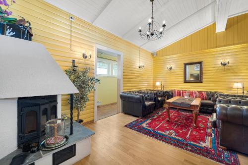 a living room with leather furniture and a fireplace at Lyngseidet Gjestegård AS in Lyngseidet