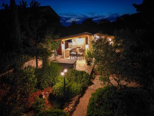 a garden at night with a house with lights at Villa Kosta in Krk