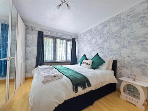 a bedroom with a large bed and a window at Morden holiday in Basildon