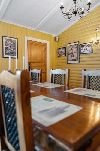 a dining room with a wooden table and chairs at Lyngseidet Gjestegård AS in Lyngseidet