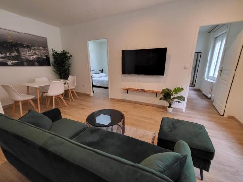 un salon avec un canapé et une télévision dans l'établissement Magnifique et confortable appartement hyper centre, à Saint-Étienne
