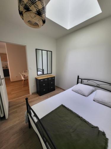 une chambre avec un grand lit et un lustre dans l'établissement Magnifique et confortable appartement hyper centre, à Saint-Étienne