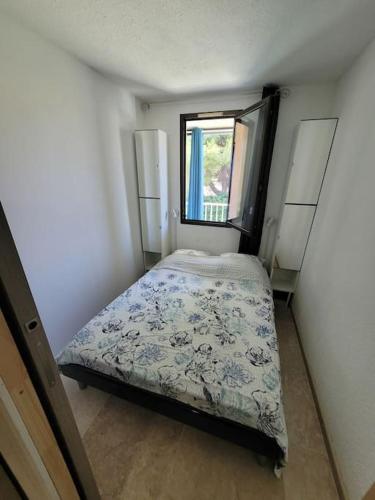 une petite chambre avec un lit et une fenêtre dans l'établissement Appartement cosy en résidence privée, bord de mer, à Six-Fours-les-Plages