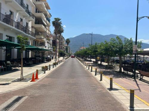 an empty street in a city with buildings and trees at Grand Luxury Apartment Seafront Kalamata in Kalamata