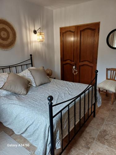 - une chambre avec un lit et une porte en bois dans l'établissement La Maison de Papé et Mamé, à LʼIsle-sur-la-Sorgue