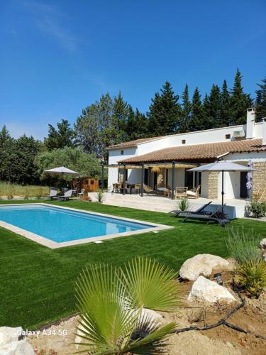 une maison avec une piscine dans une cour dans l'établissement La Maison de Papé et Mamé, à LʼIsle-sur-la-Sorgue