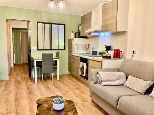 un salon avec un canapé et une table et une cuisine dans l'établissement Appartement ALBIGNY Centre Lac Annecy, à Annecy