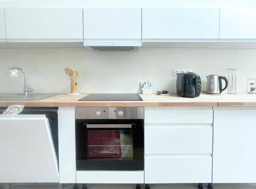 a kitchen with white cabinets and a stove top oven at Place Sainte Marguerite in Provins